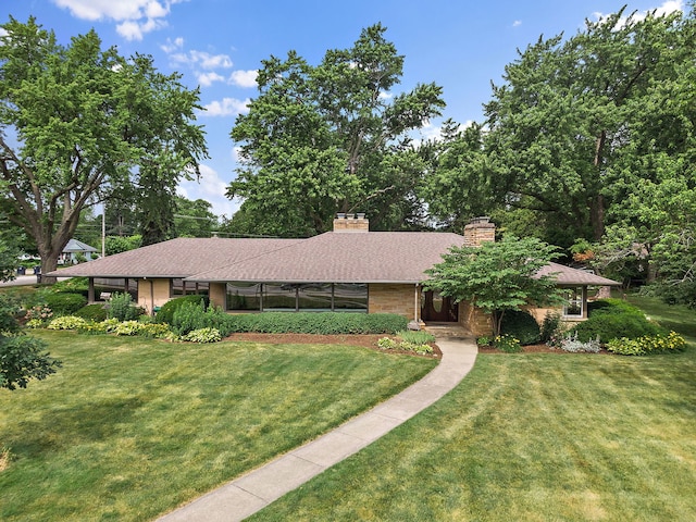 306 Wing Park Blvd, Elgin, IL 60123 - view of front of home featuring a front yard, a chimney, and brick siding