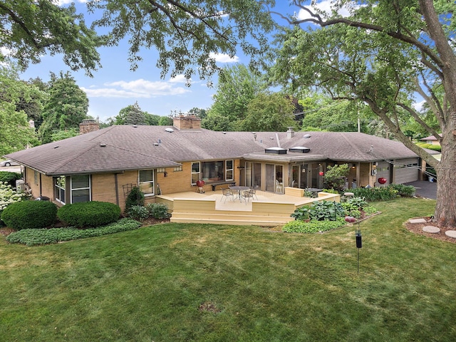 306 Wing Park Blvd, Elgin, IL 60123 - rear view of house featuring a chimney, a lawn, a deck, brick siding, and a shingled roof