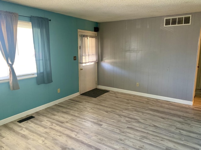 3122 Arlington Dr, Princeton, IL 61356 - spare room featuring a textured ceiling, wood finished floors, and wood walls