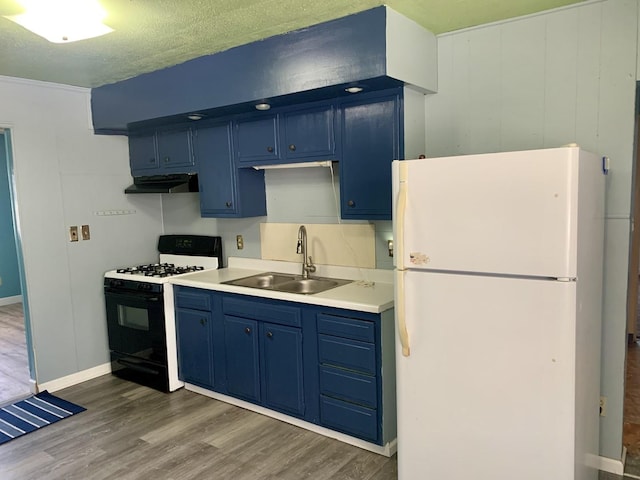3122 Arlington Dr, Princeton, IL 61356 - kitchen with freestanding refrigerator, black range with gas cooktop, blue cabinets, under cabinet range hood, and wood finished floors