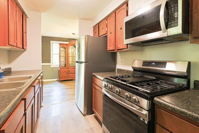 108 Poplar St, Mchenry, IL 60051 - kitchen featuring appliances with stainless steel finishes, light wood-style floors, and dark countertops