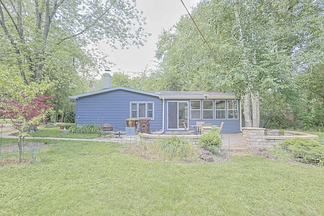 108 Poplar St, Mchenry, IL 60051 - rear view of house featuring a patio area, a lawn, a chimney, and a sunroom