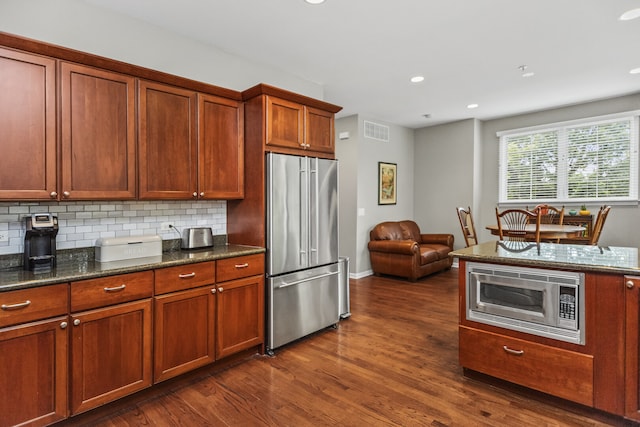 10 Park Ave, River Forest, IL 60305 - kitchen featuring appliances with stainless steel finishes, dark wood-type flooring, recessed lighting, decorative backsplash, and dark stone counters