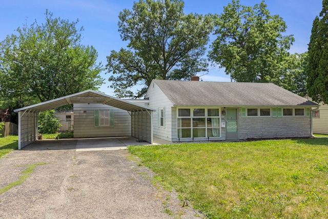 123 Tilton Park Dr, Dekalb, IL 60115 - view of front of home with asphalt driveway, a carport, a front lawn, a chimney, and stone siding