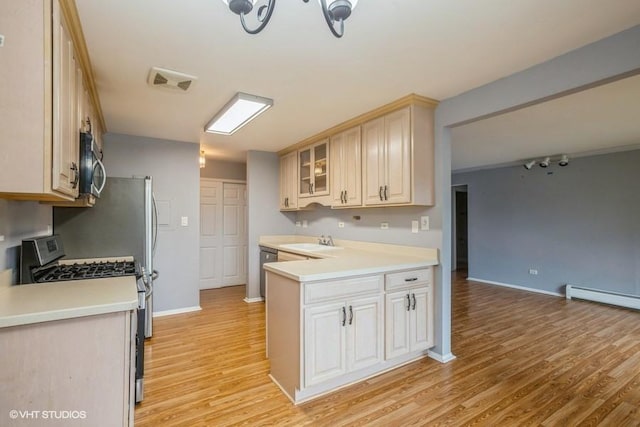 1205 E Hintz Rd Unit 206, Arlington Heights, IL 60004 - kitchen with appliances with stainless steel finishes, a baseboard heating unit, light wood-style flooring, light countertops, and glass insert cabinets