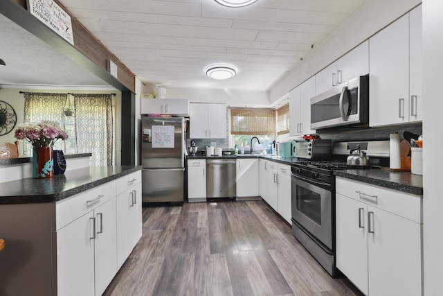 162 Grant St, Seneca, IL 61360 - kitchen featuring stainless steel appliances, dark countertops, white cabinets, and dark wood finished floors