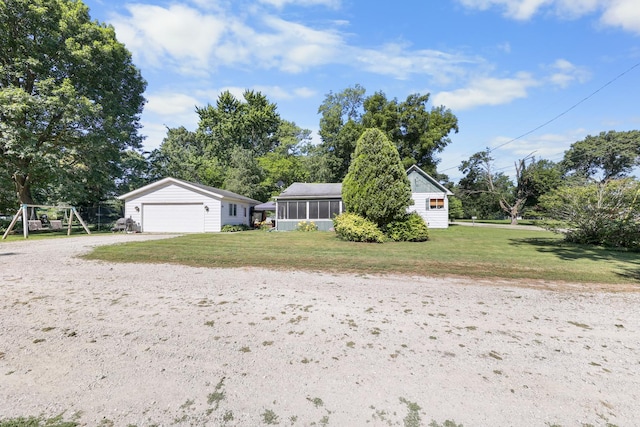 162 Grant St, Seneca, IL 61360 - view of front of home with a front lawn, a playground, driveway, and a sunroom