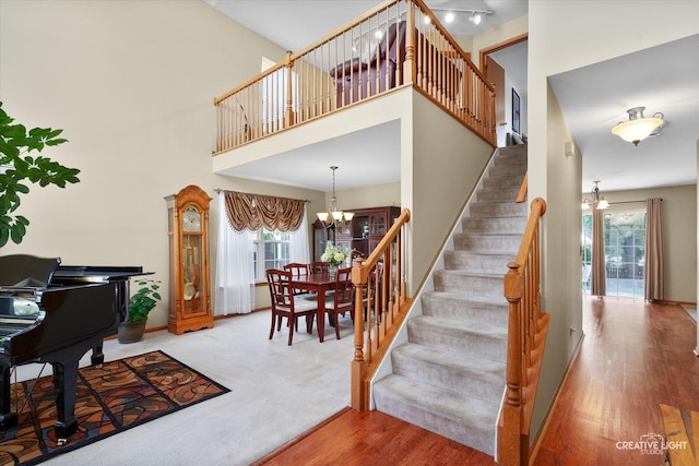 7512 Prairieside Dr, Plainfield, IL 60586 - staircase featuring healthy amount of natural light, a chandelier, wood finished floors, and a towering ceiling