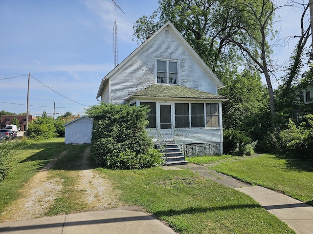 216 E Delaware St, Dwight, IL 60420 - bungalow with a storage unit, a front lawn, and a sunroom