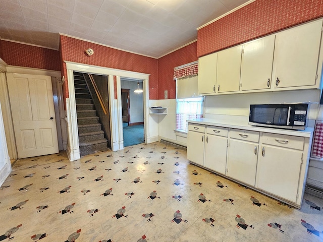 216 E Delaware St, Dwight, IL 60420 - kitchen with stainless steel microwave, light countertops, light flooring, wallpapered walls, and crown molding