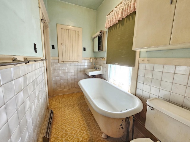216 E Delaware St, Dwight, IL 60420 - full bathroom featuring tile walls, a freestanding bath, and a wainscoted wall