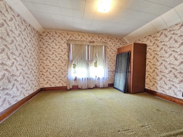 216 E Delaware St, Dwight, IL 60420 - empty room featuring wallpapered walls, vaulted ceiling, and light carpet