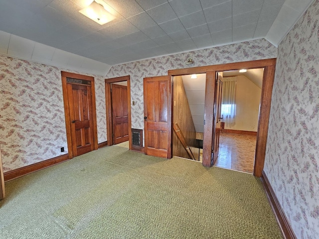 216 E Delaware St, Dwight, IL 60420 - unfurnished bedroom with wallpapered walls, vaulted ceiling, and carpet flooring