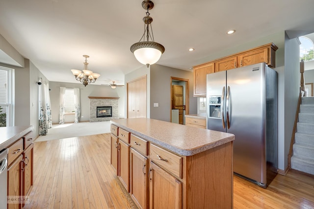 1884 Shore Line Ct, Romeoville, IL 60446 - kitchen with appliances with stainless steel finishes, a center island, light wood-style floors, a glass covered fireplace, and open floor plan