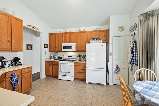 13120 Birmingham Ct, Beach Park, IL 60083 - kitchen with white appliances, vaulted ceiling, light countertops, brown cabinets, and light tile patterned floors