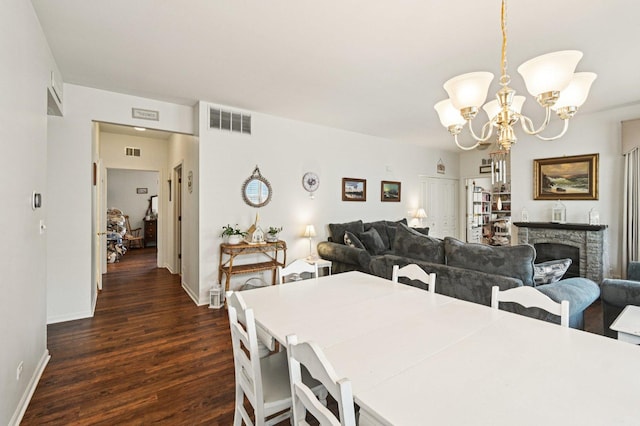 13120 Birmingham Ct, Beach Park, IL 60083 - dining room featuring dark wood-type flooring, a chandelier, and a stone fireplace