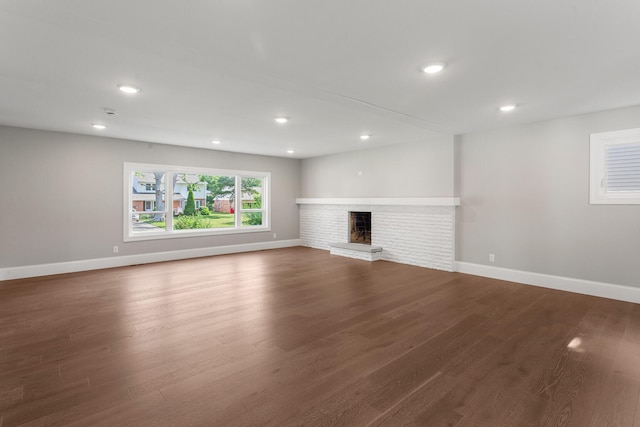 1205 Broadmoor Dr, Champaign, IL 61821 - unfurnished living room featuring dark wood-style flooring, recessed lighting, and a brick fireplace