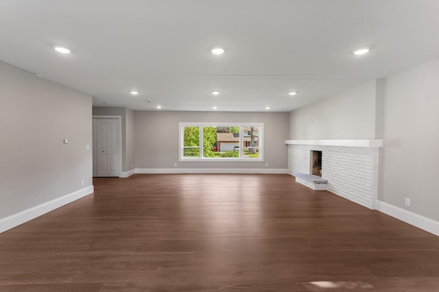 1205 Broadmoor Dr, Champaign, IL 61821 - unfurnished living room with dark wood finished floors, a brick fireplace, and recessed lighting