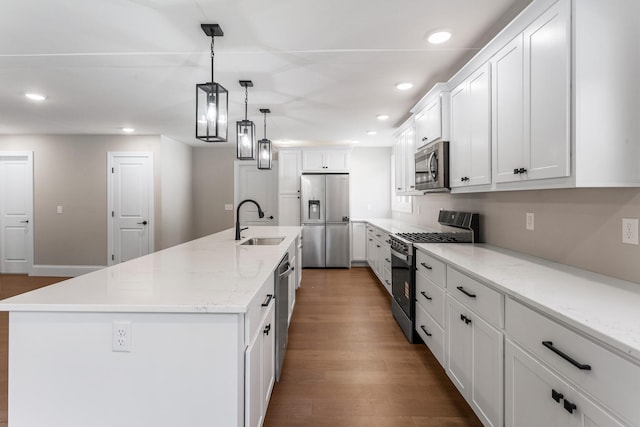 1205 Broadmoor Dr, Champaign, IL 61821 - kitchen featuring stainless steel appliances, wood finished floors, white cabinetry, a center island with sink, and recessed lighting