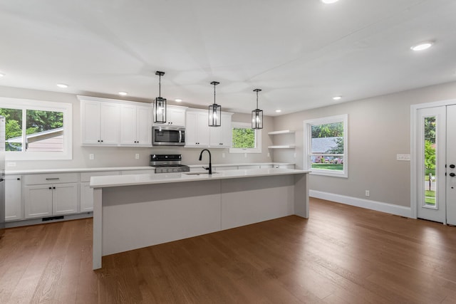 1205 Broadmoor Dr, Champaign, IL 61821 - kitchen with appliances with stainless steel finishes, wood finished floors, recessed lighting, a kitchen island with sink, and light countertops
