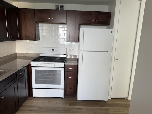 4850 S Lake Park Ave Unit 1508, Chicago, IL 60615 - kitchen with white appliances, dark brown cabinets, wood finished floors, and decorative backsplash
