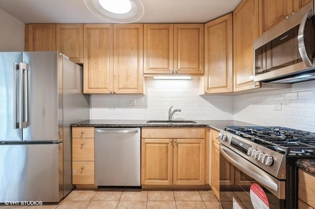 1220 Park Ave W Unit 110, Highland Park, IL 60035 - kitchen featuring appliances with stainless steel finishes, light tile patterned flooring, tasteful backsplash, and dark stone counters