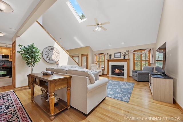 2436 Haider Ave, Naperville, IL 60564 - living area featuring high vaulted ceiling, light wood finished floors, a premium fireplace, a skylight, and a ceiling fan