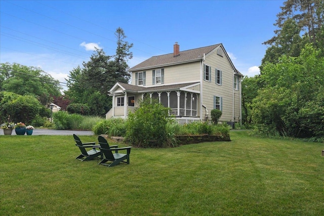 1109 N Dunton Ave, Arlington Heights, IL 60004 - back of property featuring a chimney, a lawn, a sunroom, and a shingled roof