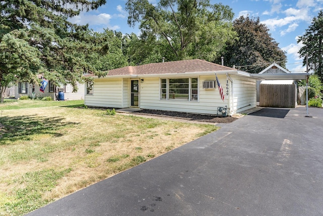 16649 W 147th Pl, Lockport, IL 60441 - ranch-style house with a front lawn, driveway, a carport, an AC wall unit, and roof with shingles