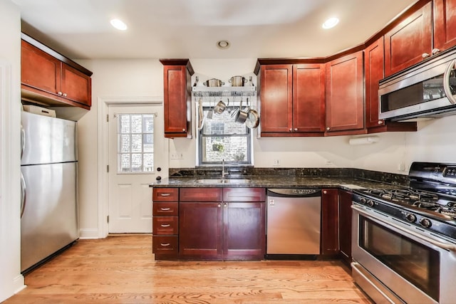 3253 W Palmer St Unit 301, Chicago, IL 60647 - kitchen featuring stainless steel appliances, dark brown cabinets, light wood-style flooring, dark stone countertops, and recessed lighting