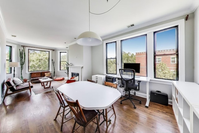 3253 W Palmer St Unit 301, Chicago, IL 60647 - dining area featuring crown molding, a glass covered fireplace, dark wood-style flooring, and a desk