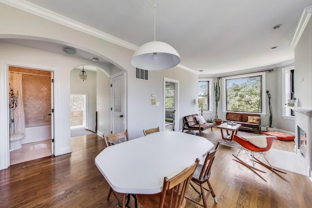 3253 W Palmer St Unit 301, Chicago, IL 60647 - dining area featuring arched walkways, healthy amount of natural light, wood finished floors, and crown molding