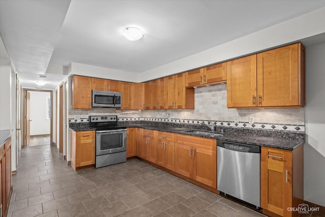 2301 Bicentennial Ave Unit 5, Crest Hill, IL 60403 - kitchen with stainless steel appliances, backsplash, dark stone counters, and brown cabinetry
