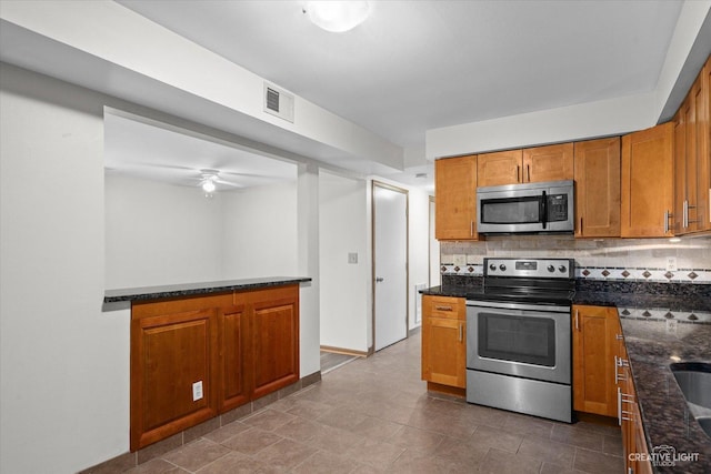2301 Bicentennial Ave Unit 5, Crest Hill, IL 60403 - kitchen with stainless steel appliances, brown cabinetry, dark stone countertops, tasteful backsplash, and ceiling fan