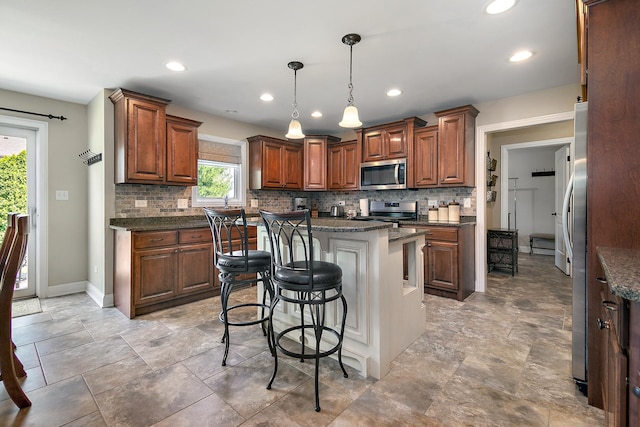 1920 Summerfield Ln, Bourbonnais, IL 60914 - kitchen featuring stainless steel appliances, a kitchen bar, backsplash, a center island, and hanging light fixtures