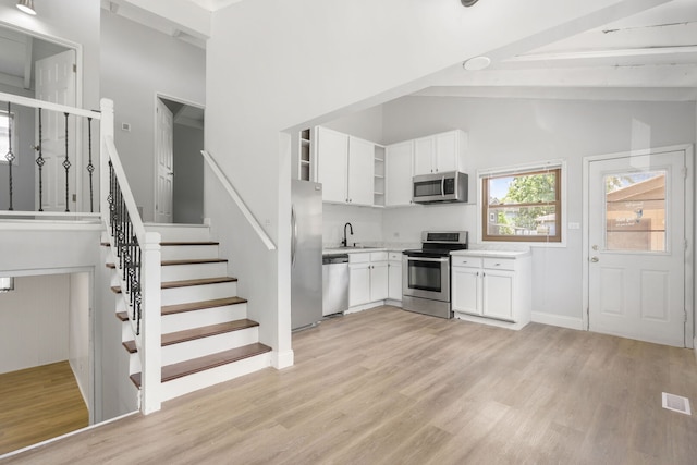 720 W Terrace St, Villa Park, IL 60181 - kitchen featuring stainless steel appliances, open shelves, light countertops, light wood-style floors, and beam ceiling