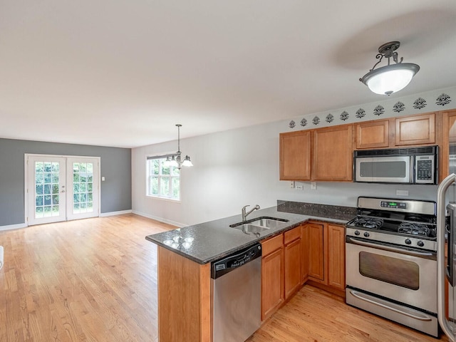 525 W Washington Ave Unit 9, Lake Bluff, IL 60044 - kitchen featuring appliances with stainless steel finishes, light wood finished floors, a peninsula, dark stone countertops, and brown cabinetry