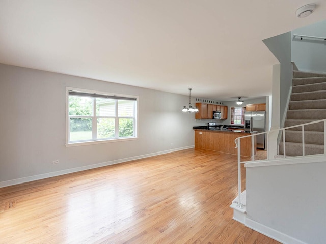 525 W Washington Ave Unit 9, Lake Bluff, IL 60044 - unfurnished living room with stairway, a chandelier, and light wood-style floors