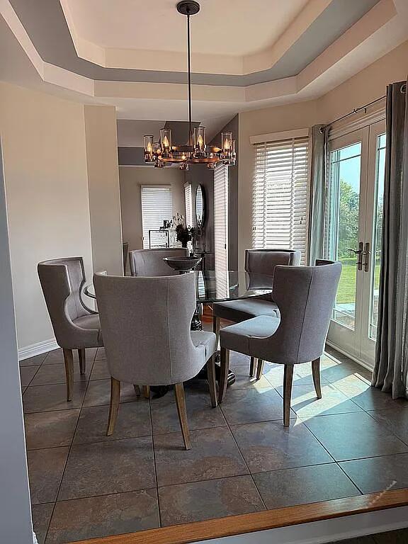 06N274 W Ridgewood Ln, Saint Charles, IL 60175 - dining space with a tray ceiling, a chandelier, healthy amount of natural light, and tile patterned floors