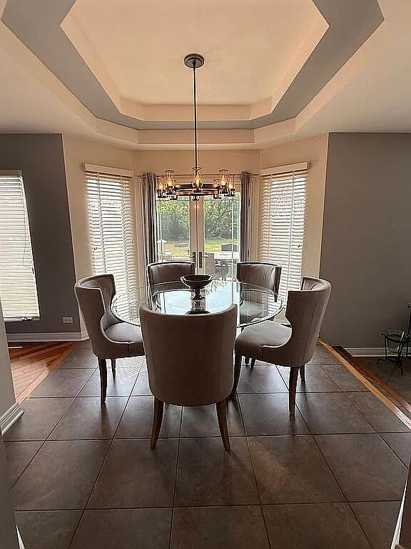 06N274 W Ridgewood Ln, Saint Charles, IL 60175 - dining area featuring a tray ceiling, a chandelier, and dark tile patterned floors
