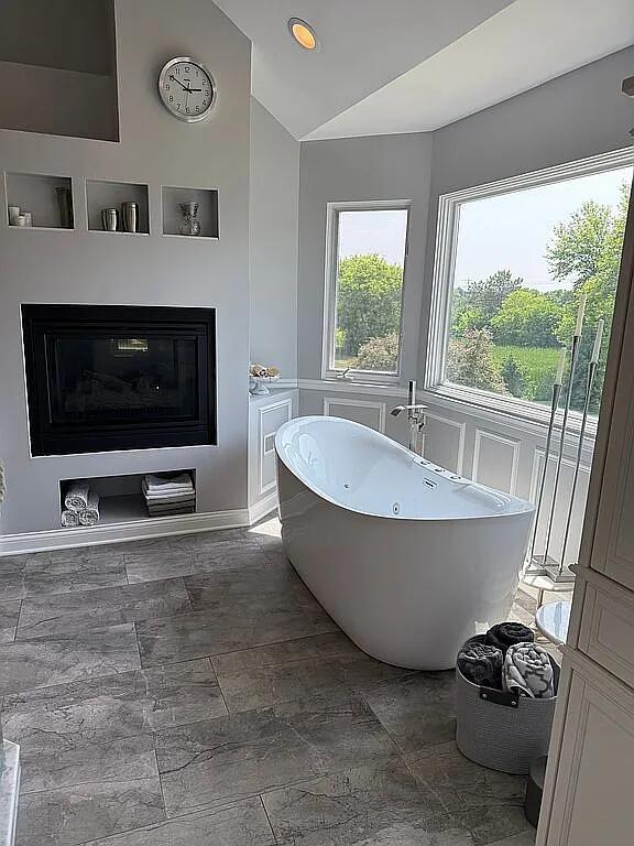 06N274 W Ridgewood Ln, Saint Charles, IL 60175 - full bathroom featuring vaulted ceiling, a soaking tub, stone finish floors, and a decorative wall