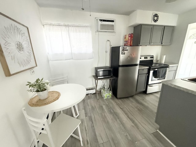 605 N Wolf Rd Unit B9, Hillside, IL 60162 - kitchen featuring appliances with stainless steel finishes, gray cabinets, a wall unit AC, and light wood finished floors