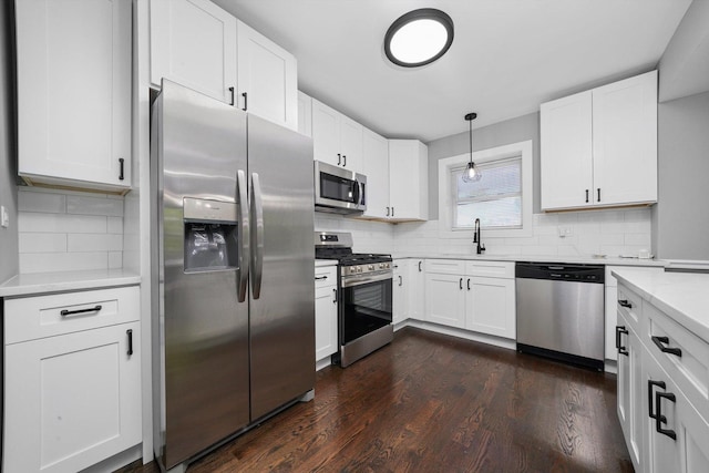 8051 S Paxton Ave, Chicago, IL 60617 - kitchen featuring stainless steel appliances, tasteful backsplash, dark wood finished floors, and white cabinetry
