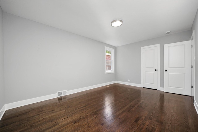 8051 S Paxton Ave, Chicago, IL 60617 - unfurnished bedroom with dark wood-style flooring and baseboards