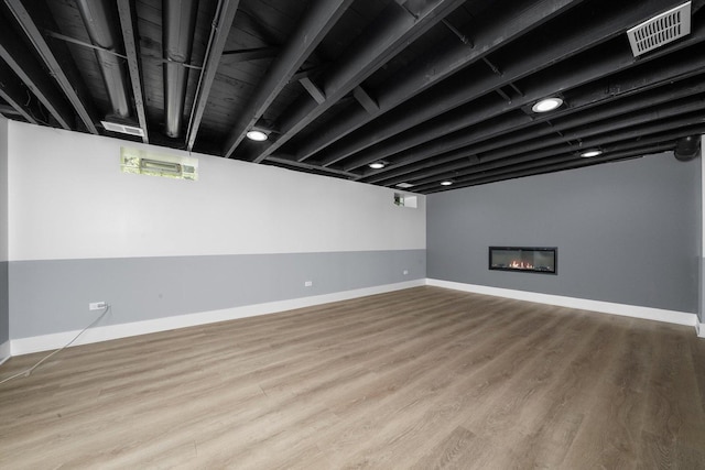 8051 S Paxton Ave, Chicago, IL 60617 - below grade area with wood finished floors and a glass covered fireplace
