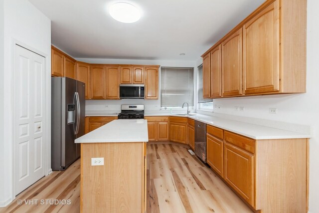 1110 Oakhill Dr, Aurora, IL 60502 - kitchen featuring appliances with stainless steel finishes, light wood-type flooring, a center island, and light countertops