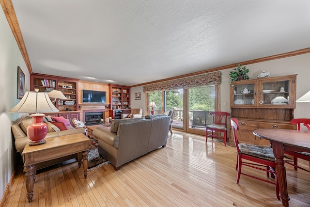10732 Revere Rd, Mokena, IL 60448 - living room with crown molding, light wood-style flooring, a glass covered fireplace, built in features, and a textured ceiling