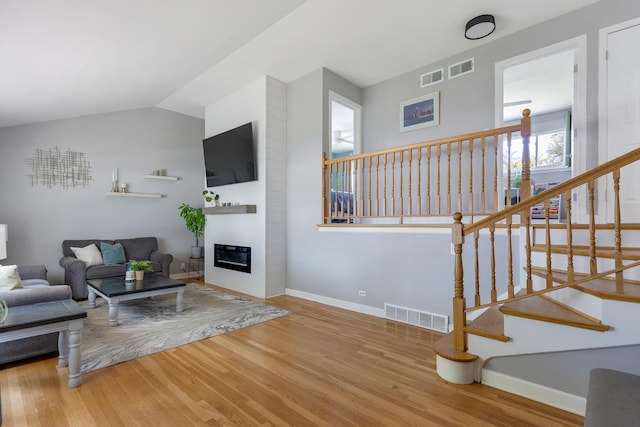 817 N Gibbons Ave, Arlington Heights, IL 60004 - living room featuring wood finished floors, lofted ceiling, a large fireplace, and stairs