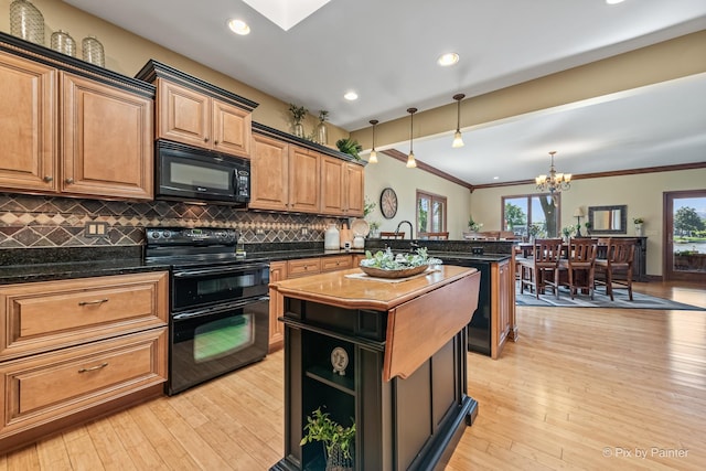 1913 N Woodlawn Park Ave, Mchenry, IL 60051 - kitchen featuring black appliances, a peninsula, decorative backsplash, a chandelier, and a kitchen island