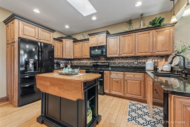 1913 N Woodlawn Park Ave, Mchenry, IL 60051 - kitchen featuring black appliances, a skylight, decorative backsplash, light wood-style floors, and recessed lighting